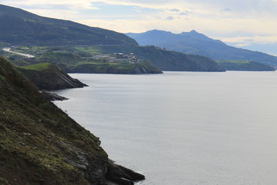 Scenic view of sea and mountains against sky