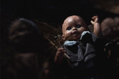 Close-up of abandoned doll in darkroom