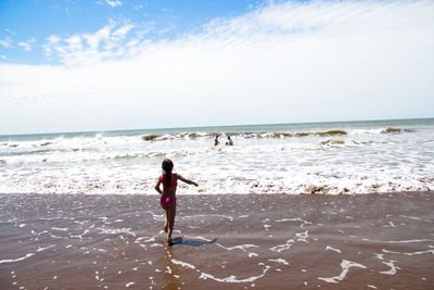 Full length of boy on beach against sky