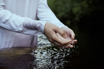 Close-up of hands over water