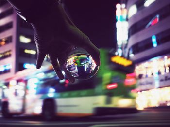 Midsection of person holding illuminated city at night