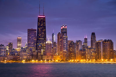 Illuminated city buildings against sky