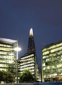 Low angle view of illuminated buildings against sky at night