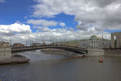 Bridge over river against sky in city