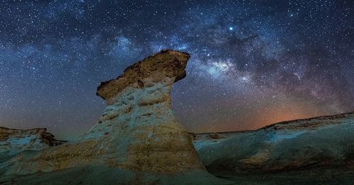 Low angle view of rock formation against sky at night