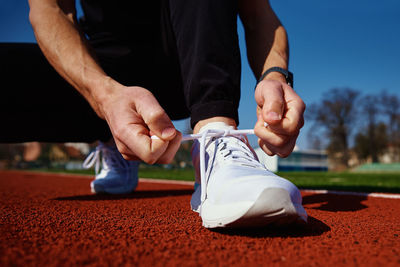 Runner get ready for run, tying sneakers shoelaces