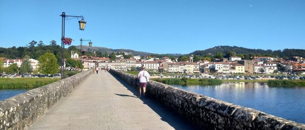 Canal amidst buildings against clear blue sky