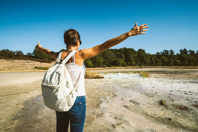 Young woman trekking to the solfatara di manziana, a sulphurous area of italy.