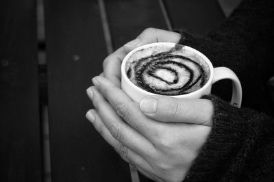 Cropped image of hand holding coffee cup