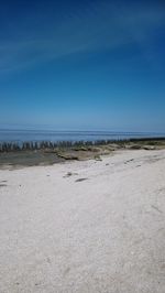 Scenic view of beach against clear blue sky