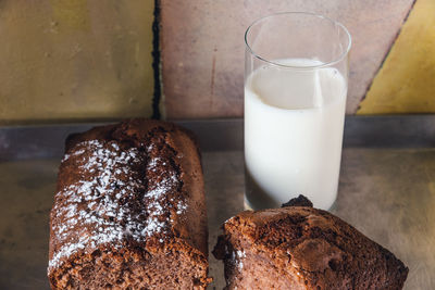 High angle view of chocolate cake with milk glass in baking tray