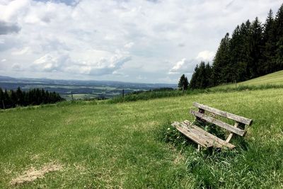 Scenic view of grassy field against cloudy sky