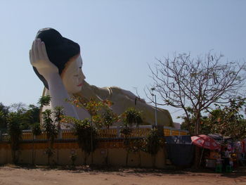 Woman with umbrella against clear sky