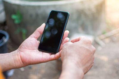 Close-up of cropped hands using smart phone