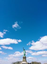 Statue of liberty against cloudy blue sky