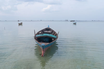 Wooden boats on sea against sky