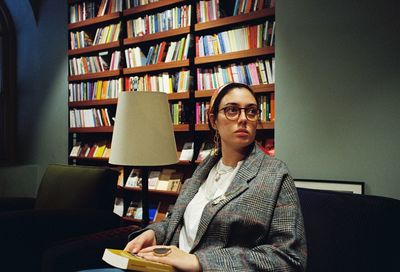 Woman looking away while sitting in library