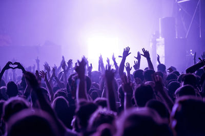 Crowd of people celebrating the new year's eve at a party. stage lights in the background