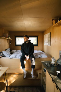 Full length of young woman sitting at home