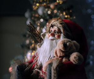 Close-up of santa claus figurine against christmas tree