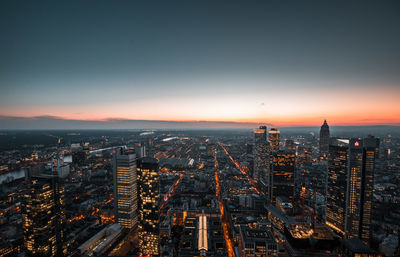 Illuminated buildings against sky during sunset