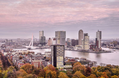 High angle view of buildings by river against sky during sunset