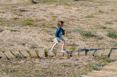High angle view of girl walking on steps in field