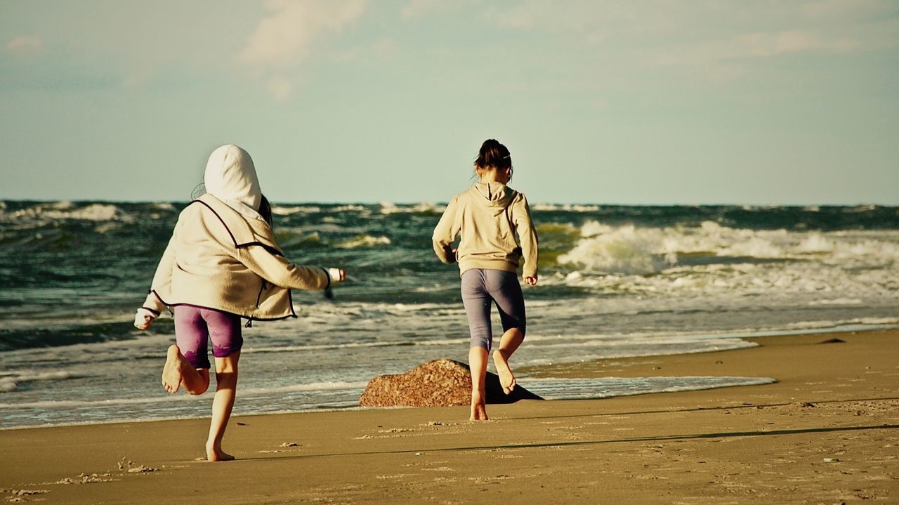 WOMAN WALKING ON BEACH