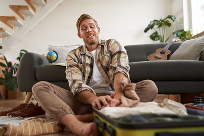 Portrait of smiling friends using mobile phone while sitting at home