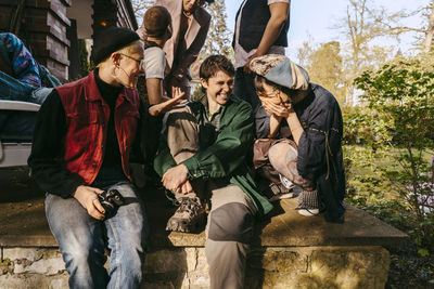 Portrait of smiling friends sitting in forest