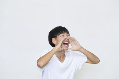 Portrait of young man standing against white background