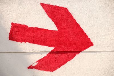 Close-up of red arrow symbol on wall