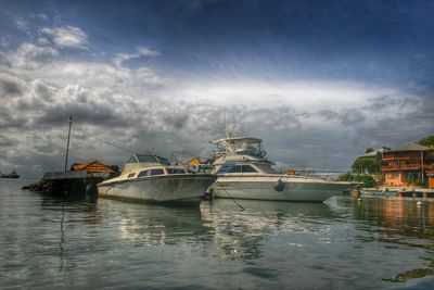 Boats sailing in river against sky