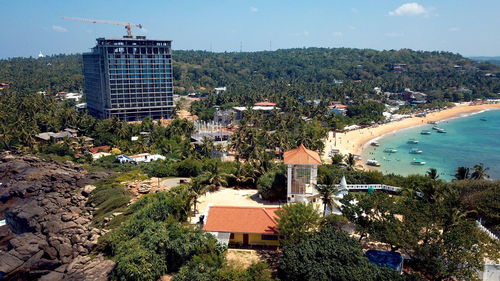 Buildings by swimming pool against sky in city