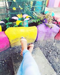 Low section of woman with multi colored umbrella