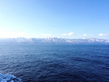 Scenic view of sea and mountains against sky