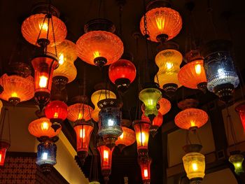 Low angle view of illuminated lanterns hanging at night