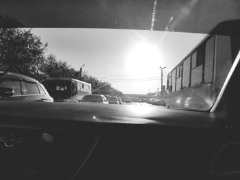 Cars on road against sky seen through car window