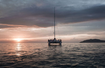 Ship sailing on sea against sky during sunset