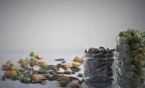 Close-up of fruits in jar on table against wall