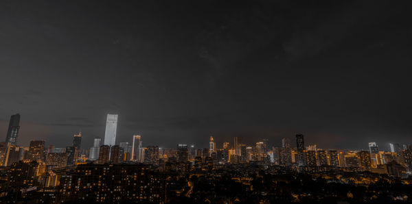 Illuminated cityscape against sky at night