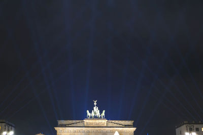 Low angle view of statue of illuminated building against sky