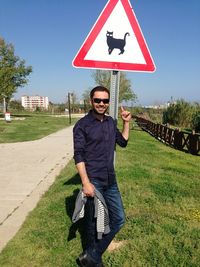 Full length portrait of man standing on roadside