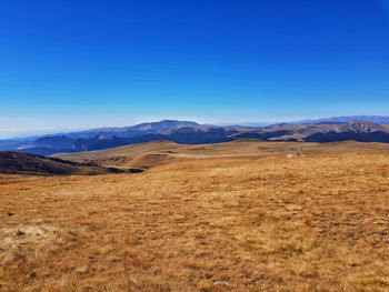 Scenic view of mountains against clear blue sky