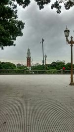 Footpath against cloudy sky