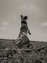 Low angle view of man sitting on field against sky