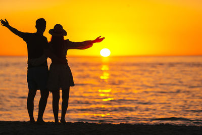 Silhouette woman standing at sunset