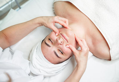 Cropped hand of massage therapist massaging customer