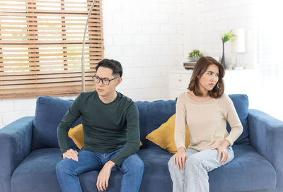 Young couple sitting on sofa at home