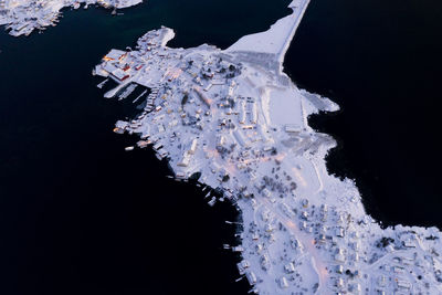 Reine village and fjord covered with snow from above, norway